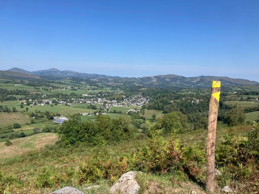 Balise jaune et vue sur la vallée et le village d'Arette