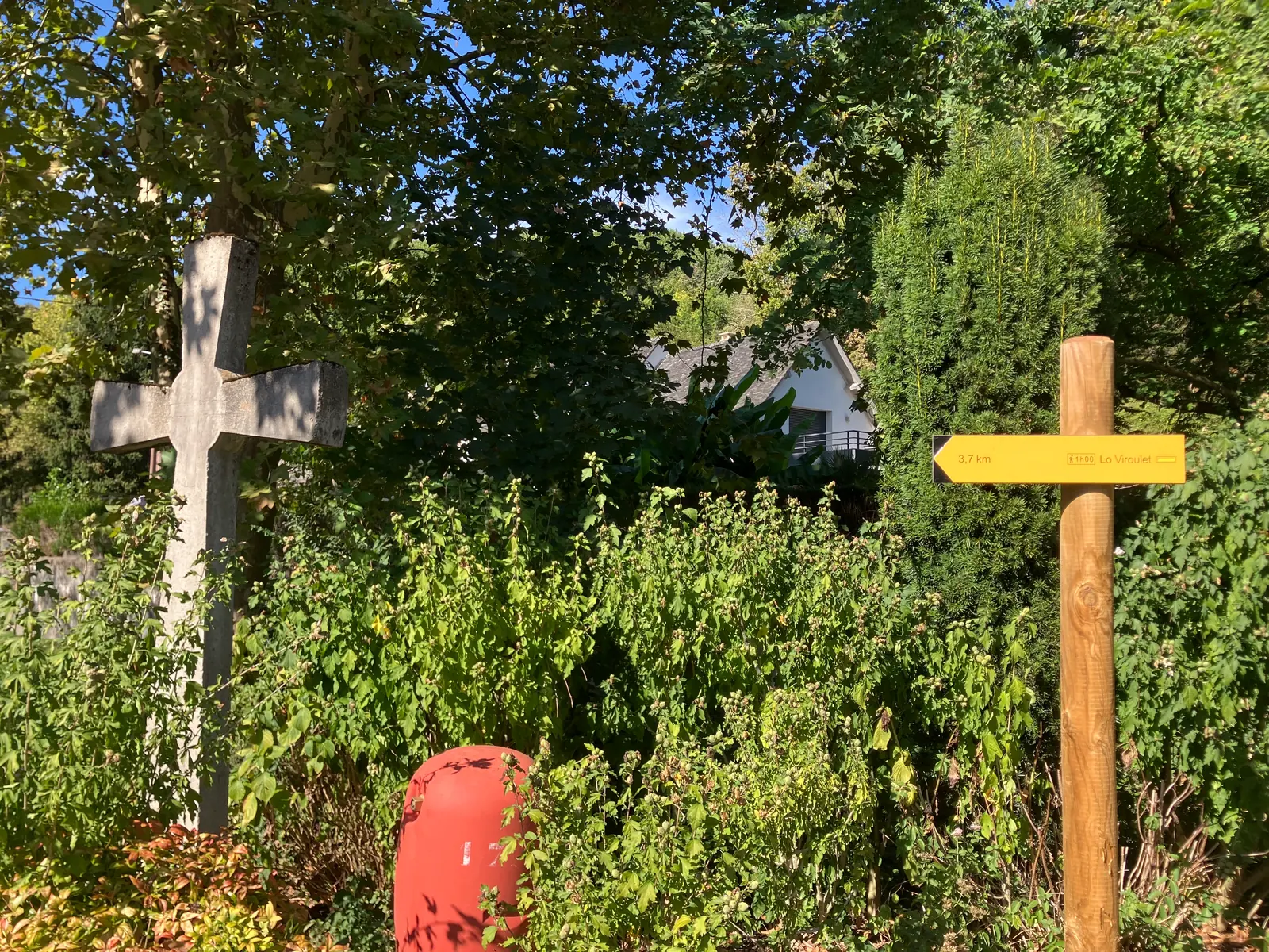 Croix de pierre et poteau indicateur jaune